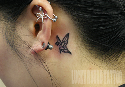 耳裏への小さな蝶のタトゥー Lucky Round Tattoo